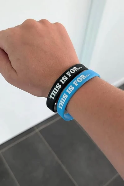 Black and blue This Is For... wristbands worn on a wrist